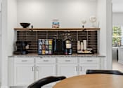 Thumbnail 41 of 51 - A kitchen with a wooden table and white cabinets.