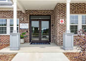 Thumbnail 35 of 51 - The front of a brick building with a glass door and a sign that says "ZIP+4" on it.