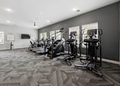 Thumbnail 34 of 51 - A gym with treadmills and elliptical machines.