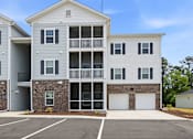 Thumbnail 50 of 51 - A two-story apartment building with a parking lot in front.