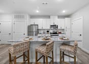 Thumbnail 27 of 51 - A kitchen with a granite countertop and white cabinets.