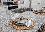 Thumbnail 12 of 51 - A kitchen counter with a plate and napkin on it.