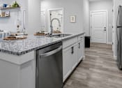 Thumbnail 11 of 51 - A kitchen with a granite countertop and stainless steel appliances.