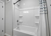 Thumbnail 20 of 51 - A white bathroom with a tub and shower.