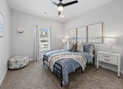 Thumbnail 1 of 51 - A bedroom with a bed, a dresser, and a ceiling fan.