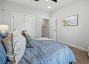 Thumbnail 6 of 51 - A bedroom with a bed in the center and a painting on the wall.