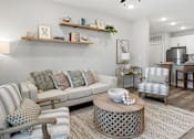 Thumbnail 4 of 51 - A living room with a grey couch and a wooden coffee table.