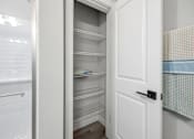 Thumbnail 8 of 51 - A white pantry with an open door revealing empty shelves.