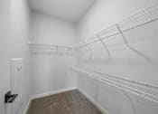 Thumbnail 18 of 51 - A white walk in closet with shelves and a door.