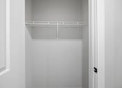 Thumbnail 13 of 51 - A white empty closet with a door on the right.