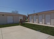 Thumbnail 9 of 14 - Row of garages with white doors and shutters at Maple Tree Apartments in LaPorte, Indiana