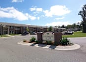 Thumbnail 3 of 6 - The Canterbury House apartments are surrounded by a well-maintained landscaped area.