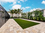 Thumbnail 11 of 94 - a courtyard with grass and trees in front of Vantage apartment buildings