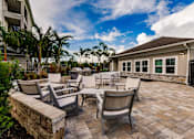 Thumbnail 9 of 94 - several chairs and tables in front of Vantage apartments clubhouse building