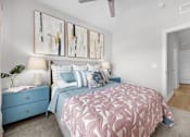Thumbnail 22 of 83 - A bedroom with a pink bedspread and blue nightstand.