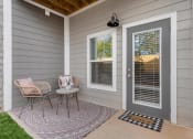 Thumbnail 29 of 42 - a front porch with two chairs and a table and a door