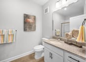 Thumbnail 27 of 83 - A bathroom with a toilet, a sink, and a painting of a flamingo.