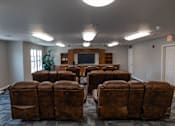 Thumbnail 28 of 41 - A room with brown leather chairs and a television.