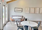 Thumbnail 4 of 17 - a dining room with tables and chairs and paintings on the wall