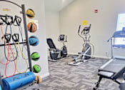 Thumbnail 6 of 17 - a gym with cardio equipment and weights at the district at highland village apartments