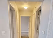 Thumbnail 14 of 17 - an empty hallway with a wood floor and white walls and doors