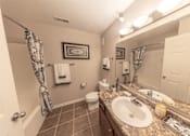 Thumbnail 3 of 43 - A bathroom with a toilet, sink, and mirror.