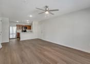 Thumbnail 3 of 30 - A room with a ceiling fan and wooden flooring.