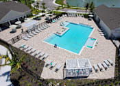 Thumbnail 23 of 83 - A large outdoor swimming pool surrounded by sun loungers and umbrellas.