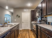 Thumbnail 24 of 34 - A kitchen with sink, stove, and closet door at the Flats at Sundown in North Port, Florida
