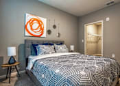 Thumbnail 26 of 34 - A bedroom with bed, artwork, and small table at the Flats at Sundown in North Port, Florida