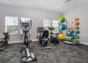 Thumbnail 14 of 42 - a gym with cardio equipment and weights in a room with windows