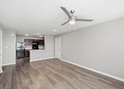 Thumbnail 29 of 45 - A room with a ceiling fan and wooden flooring.