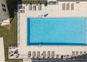 Thumbnail 38 of 58 - A large blue swimming pool surrounded by lounge chairs and umbrellas.