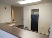 Thumbnail 37 of 41 - A kitchen with a black fridge and a white door.