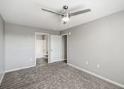 Thumbnail 38 of 45 - A room with a ceiling fan and carpeted floor.
