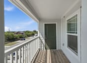 Thumbnail 42 of 45 - A balcony with a green door and a window.