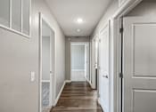 Thumbnail 41 of 45 - A long hallway with white doors and a light on the ceiling.