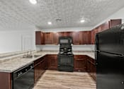 Thumbnail 20 of 34 - A kitchen with black appliances and wooden cabinets.