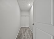 Thumbnail 31 of 34 - A hallway with a striped carpet and white walls.