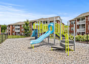 Thumbnail 15 of 34 - A playground with a blue slide and yellow railing.