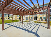 Thumbnail 16 of 45 - A wooden pergola provides shade over a walkway.