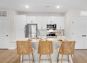 Thumbnail 41 of 83 - A kitchen with white cabinets and a stainless steel refrigerator.