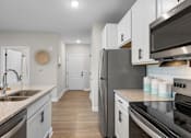 Thumbnail 39 of 83 - A modern kitchen with a stainless steel refrigerator and oven.
