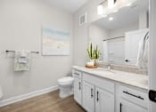 Thumbnail 50 of 83 - A bathroom with a toilet, sink, and a painting on the wall.
