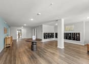 Thumbnail 10 of 39 - A spacious room with wooden floors and a white ceiling.
