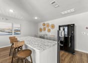 Thumbnail 8 of 39 - A kitchen with a marble countertop and a fridge.