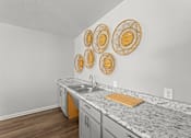 Thumbnail 3 of 39 - A kitchen with a marble countertop and wooden cabinets.