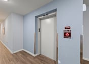 Thumbnail 5 of 39 - A hallway with a sign on the wall that says "Elevator".