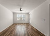 Thumbnail 17 of 39 - A room with a ceiling fan and wooden flooring.
