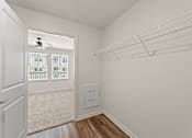 Thumbnail 27 of 39 - A white closet with a doorway leading to a balcony.